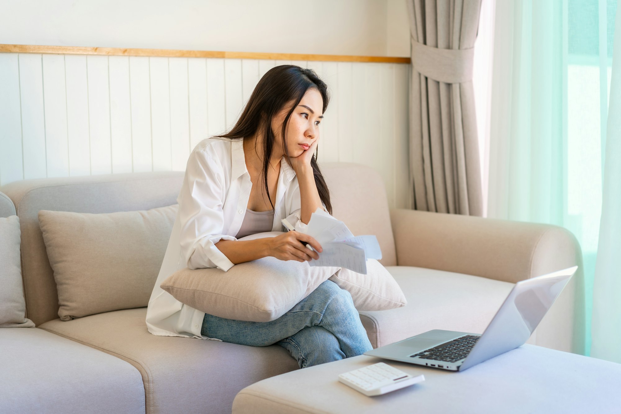 Stressed woman calculating and planning household expenses and bills reflecting financial